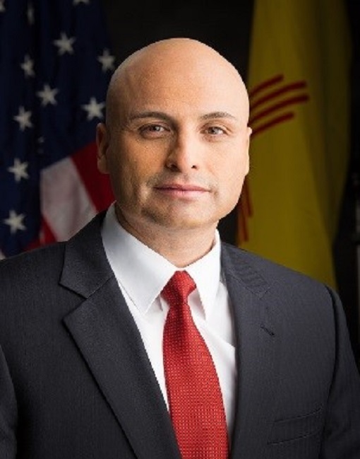 Head shot of a man in a suit wearing a red tie, facing camera